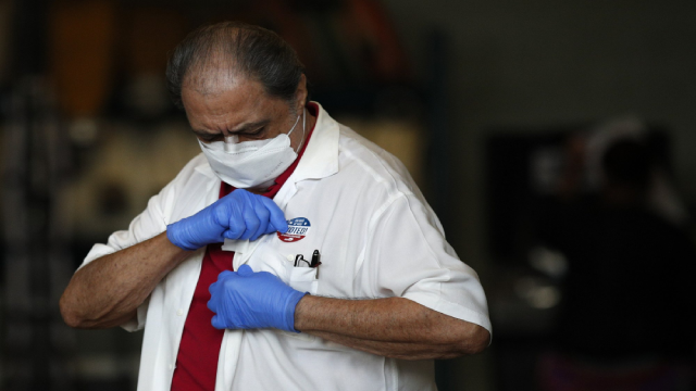 Một người đàn ông đeo găng tay và đeo mặt nạ để bảo vệ khỏi COVID-19 dán nhãn 