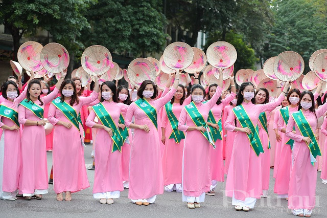 Khối áo dài mùa Xuân (màu hồng) cầm nón trắng, đeo dải băng xanh lá cây - tượng trưng cho hy vọng, hạnh phúc và bình an.