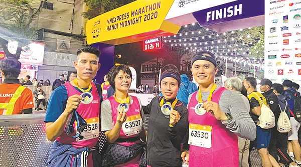 Nguyễn Thu Huyền (thứ 2 từ tr&aacute;i sang) c&ugrave;ng đồng nghiệp tham gia giải chạy Hanoi Midnight 2020