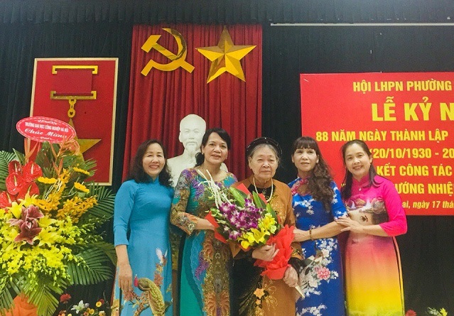 Mẹ Việt Nam Anh h&ugrave;ng Nguyễn Thị Xuyến c&ugrave;ng con d&acirc;u Nguyễn Thị M&ugrave;i (ngo&agrave;i c&ugrave;ng, tay phải) v&agrave; c&aacute;c c&aacute;n bộ Phụ nữ phường