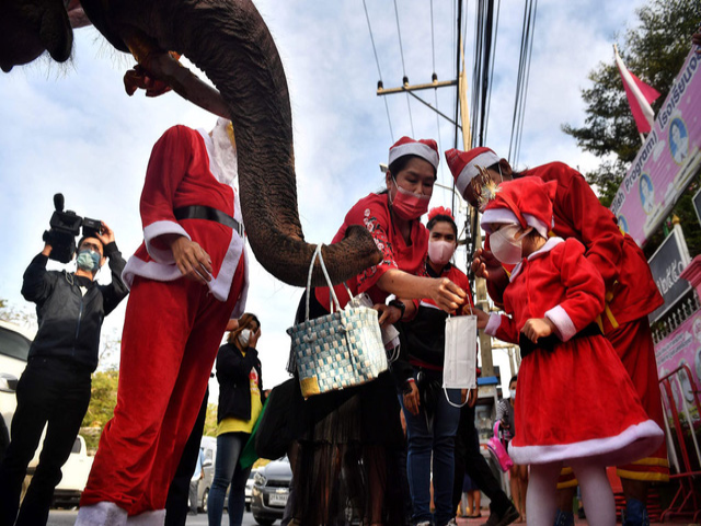 Học sinh nhận khẩu trang từ ông già Noel tại một trường học ở Ayutthaya, Thái Lan.