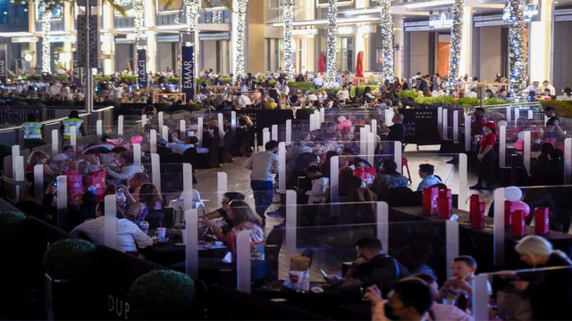 Thực khách ăn uống tại trung tâm thương mại Dubai Mall Promenade và chờ xem pháo hoa bắn gần Burj Khalifa. Tất cả phải duy trì giãn cách xã hội để phòng dịch.