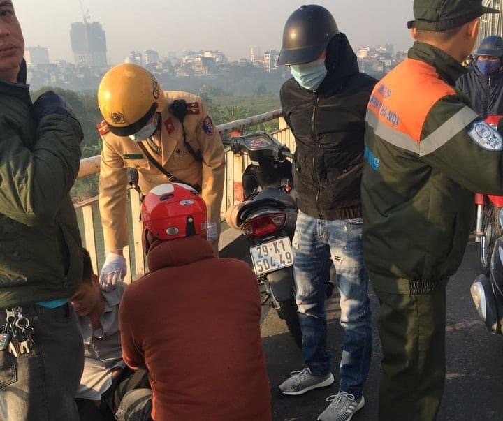 Cảnh sát giao thông và người dân đang khuyên nhủ thanh niên có ý định nhảy cầu tự tử