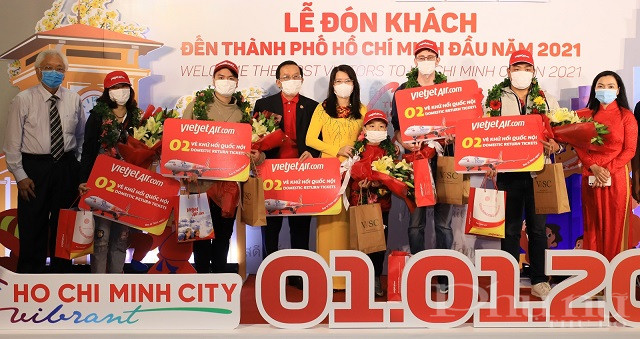 Phó Tổng giám đốc Vietjet Đỗ Xuân Quang (thứ 3 từ trái qua), Giám đốc Sở Du lịch TP.HCM Nguyễn Thị Ánh Hoa (thứ 4 từ trái qua) và cơ quan ban ngành liên quan trao hoa và tặng món quà giá trị và ý nghĩa cho hành khách may mắn.