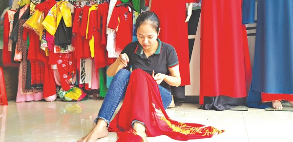 Chị  Vũ Thị Thu Hằng đang khâu đường tà áo dài