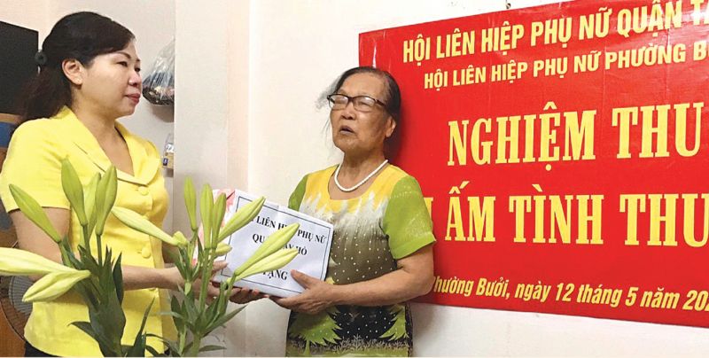 Chị B&ugrave;i Thị Ngọc Th&uacute;y &ndash; Chủ tịch Hội LHPN quận T&acirc;y Hồ tặng qu&agrave; cho gia đ&igrave;nh hội vi&ecirc;n trong ng&agrave;y b&agrave;n giao M&aacute;i ấm t&igrave;nh thương tại phường Bưởi.