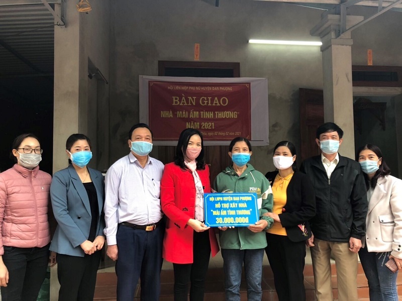 Nguyễn Thị Bảy- Chủ tịch Hội LHPN huyện ( người mặc áo đỏ)  trao hỗ trợ xây nhà“Mái ấm tình thương” cho hội viên phụ nữ thuộc hộ cận nghèo (Chị Thiều Thị Biết- Thôn 11 xã Trung Châu, huyện Đan Phượng