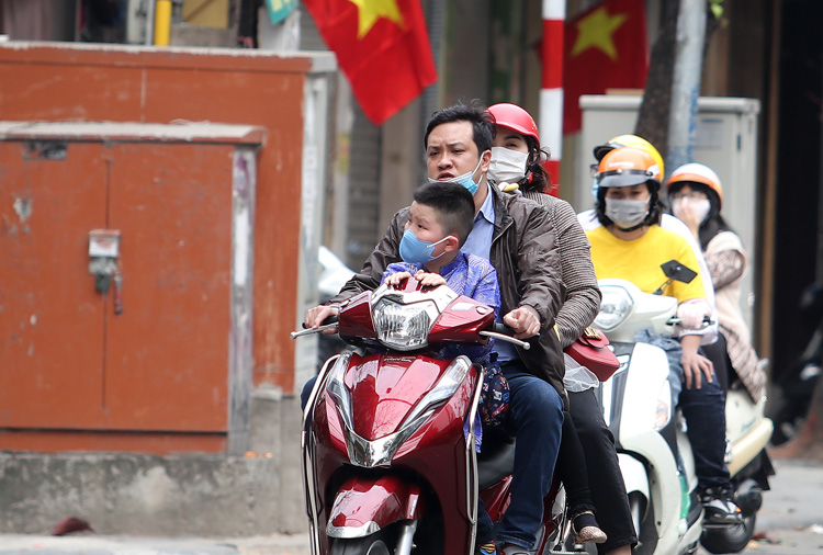 Một gia đ&igrave;nh kh&ocirc;ng đội mũ bảo hiểm lưu th&ocirc;ng tr&ecirc;n tuyến phố H&agrave;ng B&ocirc;ng.