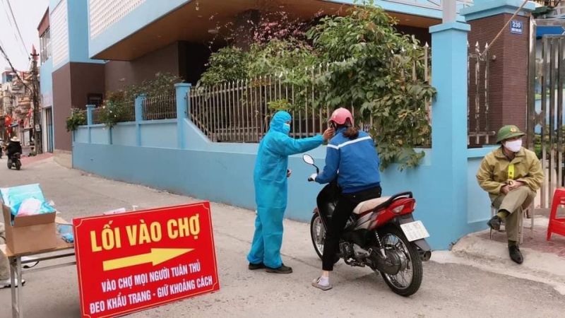 Đo th&acirc;n nhiệt cho người d&acirc;n ra v&agrave;o khu vực chợ ở Hải Dương.