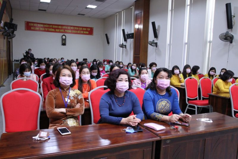 Buổi ch&agrave;o cờ đầu ti&ecirc;n của th&aacute;ng 3 tại hội trường Hội LHPN H&agrave; Nội rực rỡ sắc m&agrave;u của những t&agrave; &aacute;o d&agrave;i. C&aacute;c c&aacute;n bộ, nh&acirc;n vi&ecirc;n kh&ocirc;ng qu&ecirc;n đeo khẩu trang ph&ograve;ng dịch Covid-19