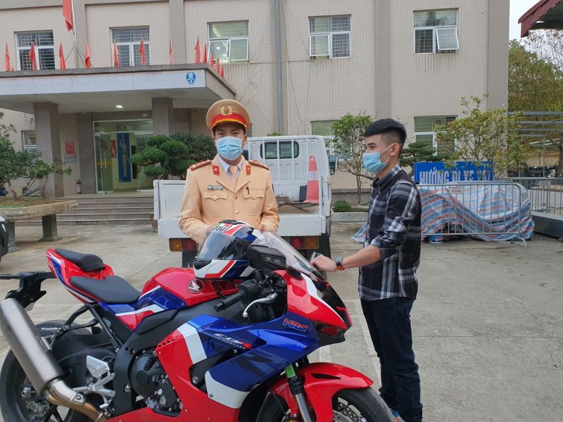 Trần Trung Kiên đứng bên chiếc xe mô tô đã điều khiển tốc độ cao đi vào đường Trần Trung Kiên đứng bên chiếc xe mô tô đã điều khiển tốc độ cao đi vào đường