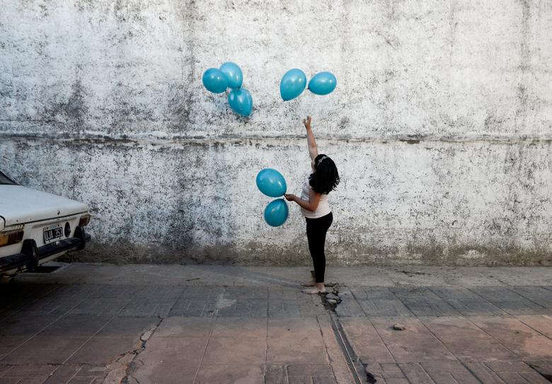 Michell, cháu gái của Rosalia Reyes - người bị kết án 8 năm tù sau khi để con chết trong một lần sinh nở tại nhà - chơi với bóng bay trong bữa tiệc chào đón Rosalia về nhà ở Zarate, Argentina.