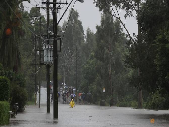 Một người lội qua d&ograve;ng nước lũ gần s&ocirc;ng Nepean đang d&acirc;ng cao khi bang New South Wales trải qua đợt lụt tr&ecirc;n diện rộng.