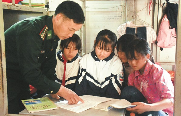 Thượng úy Lìu Láo Lanh kèm các em nhỏ học bài