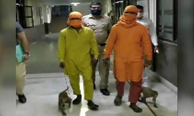 Hai người đàn ông bị cảnh sát New Delhi bắt cùng hai con khỉ hôm 8/4. Ảnh: ANI.