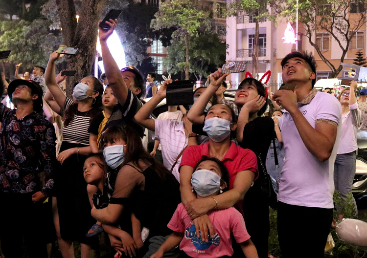 Mọi người hướng về phía sân khấu chính để theo dõi những quả pháo hoa bắn lên cao. Mọi người hướng về phía sân khấu chính để theo dõi những quả pháo hoa bắn lên cao.