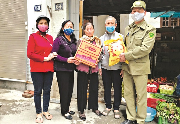 Bà Nguyễn Thị Sáng và bà Nguyễn Thanh Bình tặng quà cho các gia đình bị ảnh hưởng bởi dịch Covid -19