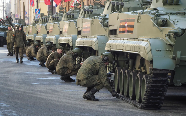 Binh sĩ đang kiểm tra xe bọc thép trước khi bắt đầu diễu hành.