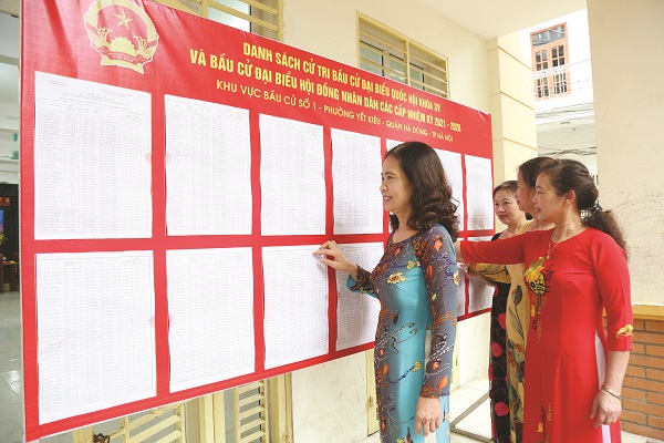 Cử tri H&agrave; Nội chăm ch&uacute; nghi&ecirc;n cứu về c&aacute;c ứng cử vi&ecirc;n ĐBQH v&agrave; ĐBHĐND c&aacute;c cấp. (Ảnh: V.N)