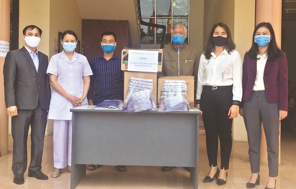 Chị S&aacute;i Thị Hường &ndash; Chủ tịch Hội LHPN x&atilde; Li&ecirc;n H&agrave;, huyện Đan Phượng (thứ 2 từ phải sang) c&ugrave;ng đo&agrave;n c&ocirc;ng t&aacute;c tặng mũ chắn giọt bắn cho tuyến đầu chống dịch tại địa phương.