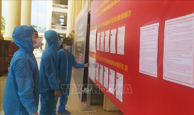 C&aacute;c chiến sĩ v&agrave; c&ocirc;ng d&acirc;n xem tiểu sử ứng cử vi&ecirc;n ni&ecirc;m yết tại khu c&aacute;ch ly ph&ograve;ng, chống dịch COVID-19 Trường Qu&acirc;n sự Bộ Tư lệnh Thủ đ&ocirc; H&agrave; Nội. Ảnh: TTXVN ph&aacute;t