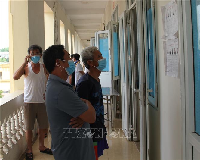 Người d&acirc;n nghi&ecirc;n cứu tiểu sử c&aacute;c ứng cử vi&ecirc;n ni&ecirc;m yết tại khu c&aacute;ch ly. Ảnh: TTXVN ph&aacute;t