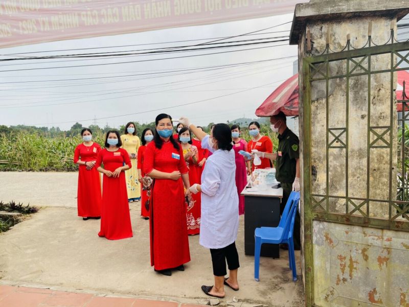 Chị em được đo thân nhiệt trước khi vào khu vực bỏ phiếu