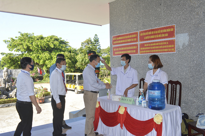 Kiểm tra th&acirc;n nhiệt, s&aacute;t khuẩn cho c&aacute;c cử tri trước khi v&agrave;o khu vực bỏ phiếu tại huyện đảo Cồn Cỏ.