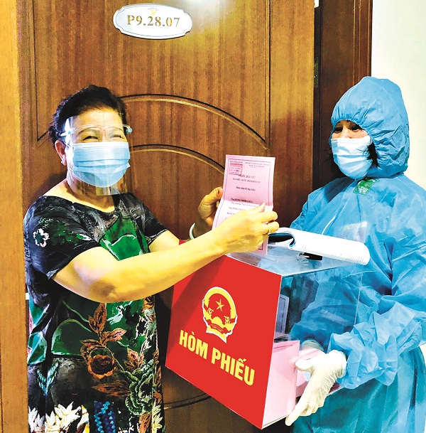 Chị Nguyễn Thị Quỳnh Nga, chi hội trưởng chi hội PN số 14 (phường Mai Động) mang hòm phiếu tới tận hộ gia đình trong tòa nhà. Park 9. Ảnh: NVCC