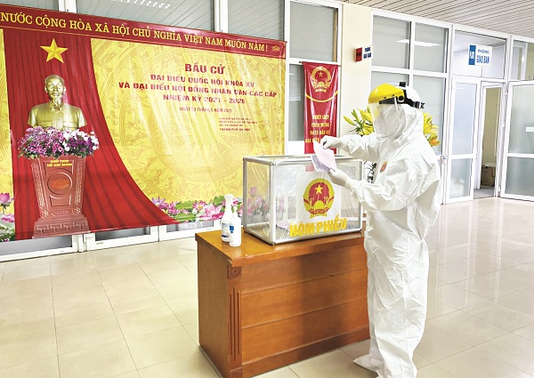 Người bệnh, người nhà người bệnh, cán bộ y tế, người lao động tại khu cách ly BV K khi tham gia bỏ phiếu đều mặc đồ bảo hộ và đảm bảo giãn cách 3m.  Ảnh: BVCC
