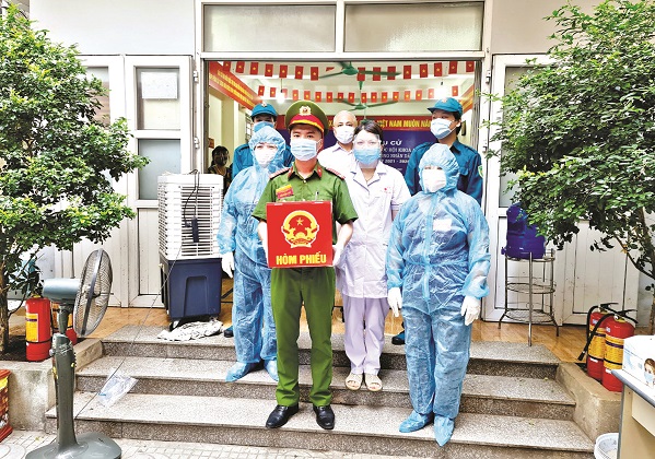 Y bác sĩ BV Bệnh Nhiệt đới TƯ vận chuyển hòm phiếu tới từng khoa, phòng bệnh để bệnh nhân thực hiện quyền công dân, tham gia bầu cử. Ảnh: Đặng Thanh