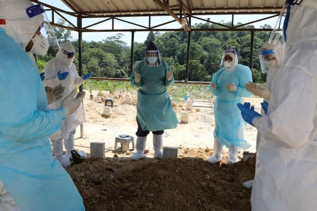 Các thành viên Đội quản lý tang lễ Malaysia đang cầu nguyện do người tử vong vì Covid-19.