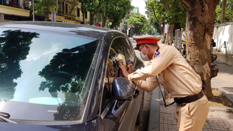 C&aacute;n bộ CSGT d&aacute;n giấy phạt nguội đối với xe &ocirc; t&ocirc; dừng đỗ sai quy định