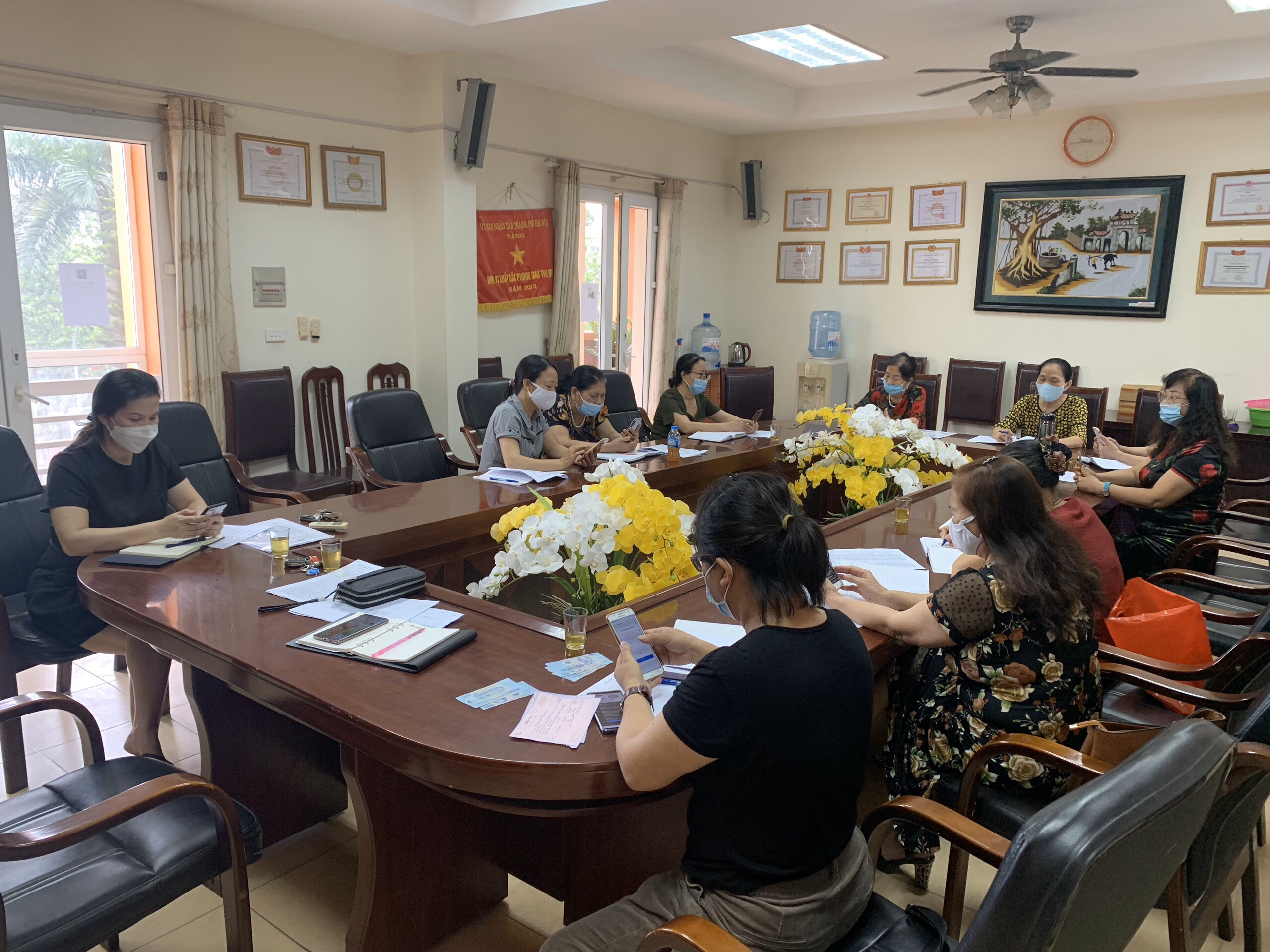 Các cán bộ, hội viên Hội LHPN quận Hà Đông chăm chú lắng nghe hội nghị qua fanpage và phần mềm Zoom