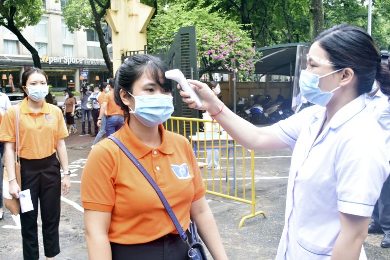 Th&iacute; sinh được đo th&acirc;n nhiệt, rửa tay s&aacute;t khuẩn tại cổng trường thi