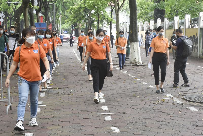 Th&iacute; sinh đi v&agrave;o từ cổng điểm thi đảm bảo gi&atilde;n c&aacute;ch theo quy định. Người nh&agrave; th&iacute; sinh được lực lượng t&igrave;nh nguyện hướng dẫn di chuyển về c&aacute;c điểm chờ thi.