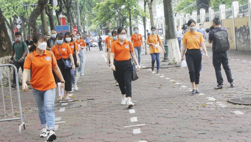 hí sinh được phân làn đi vào từ cổng điểm thi đảm bảo giãn cách theo quy định. Cùng lúc này, người nhà thí sinh được lực lượng tình nguyện hướng dẫn di chuyển về các điểm chờ thi