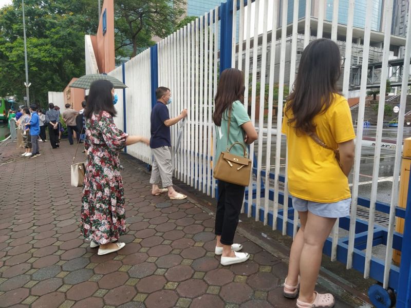Các con đã vào phòng thi nhưng một số cha mẹ vẫn xin nán lại, đứng giữ giãn  cách để   dõi theo con từ xa thêm chút nữa