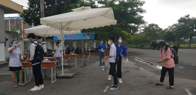 Các thí sinh đi theo phân luồng vào khử khuẩn, đo thân nhiệt trước khi vào trường thi