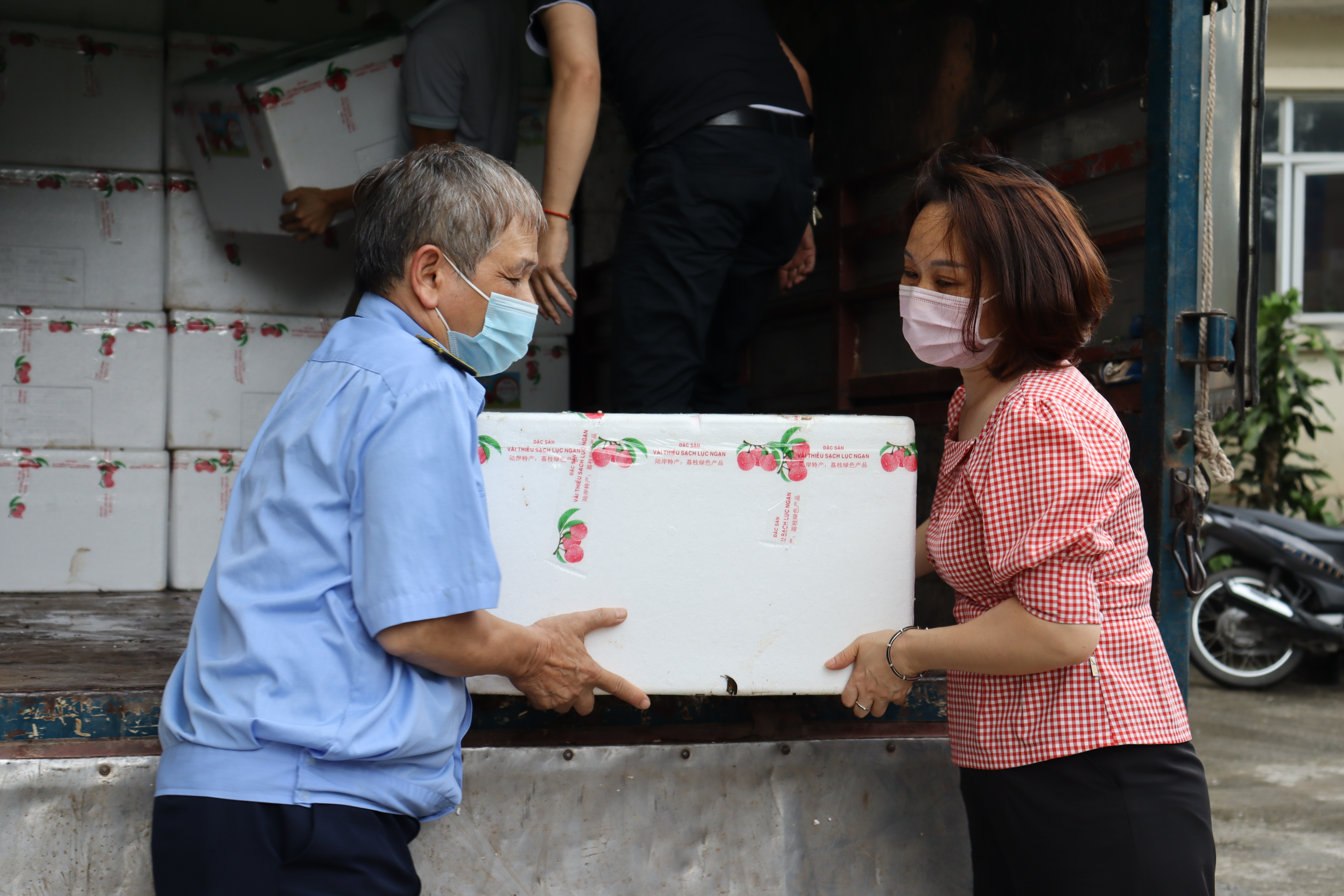 Phó Chủ tịch Hội LHPN Hà Nội Phạm Thị Thanh Hương cùng cán bộ, nhân viên Hội LHPN Hà Nội chung tay dỡ các thùng vải