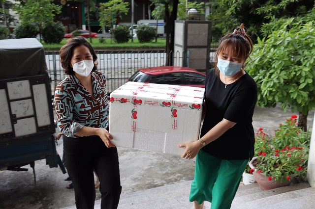 Với số lượng lớn, Chủ tịch Hội LHPN Hà Nội Lê Kim Anh (áo xanh) cũng chung tay dỡ các thùng vải thiều từ trên xe xuống, sẵn sàng để các đơn vị đến tiếp nhận.