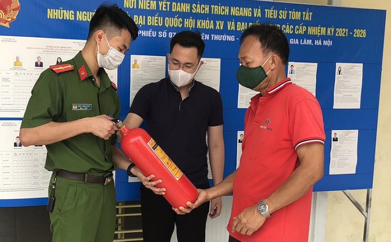 Lực lượng chức năng hướng dẫn người dân sử dụng thiết bị phòng cháy chữa cháy.