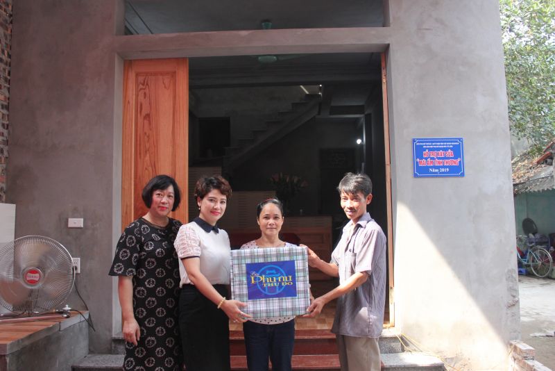 Bà Lê Quỳnh Trang, TBT báo PNTD (thứ 2 từ trái qua) bàn giao Mái ấm tình thương cho gia đình bà Quách Thị Tâm, phường Liên Mạc, quận Bắc Từ Liêm. (Ảnh Quỳnh Anh)