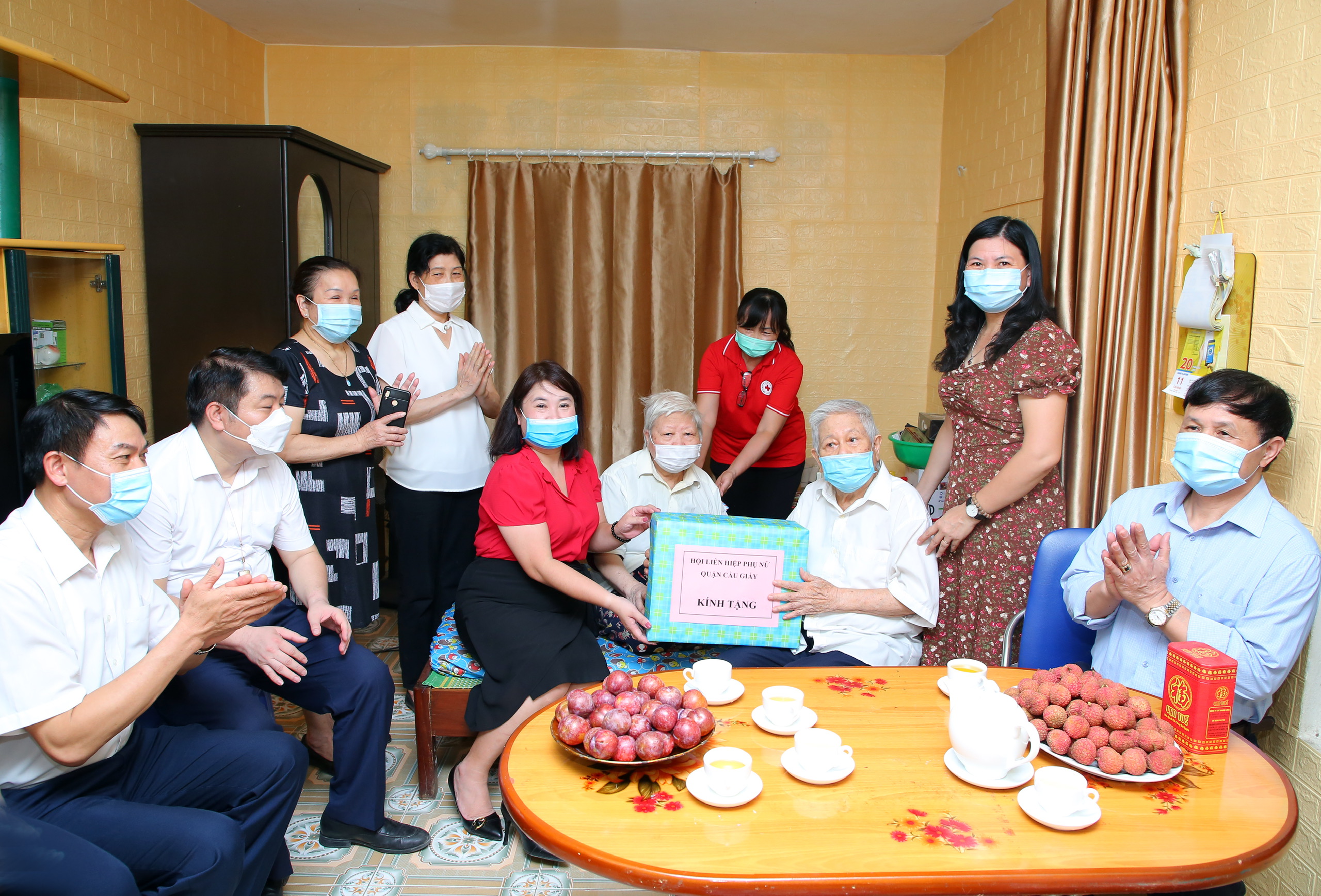 Bà Nguyễn KIm Lê (người ngồi áo đỏ), Chủ tịch Hội LHPN quận Cầu Giấy tặng quà chúc mừng gia đình hội viên Đinh Thị Hoàng Yến