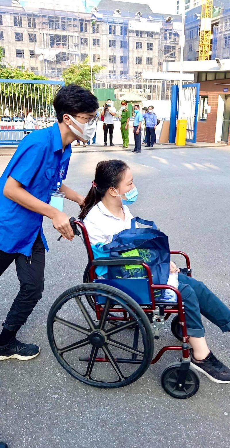 Một thí sinh gặp khó khăn trong vận động được hỗ trợ đưa vào phòng thi.