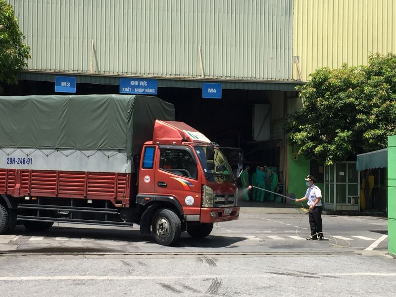 Công nhân của Công ty Nhựa Hà Nội đang thực hiện việc khử khuẩn với các xe hàng ra, vào công ty.