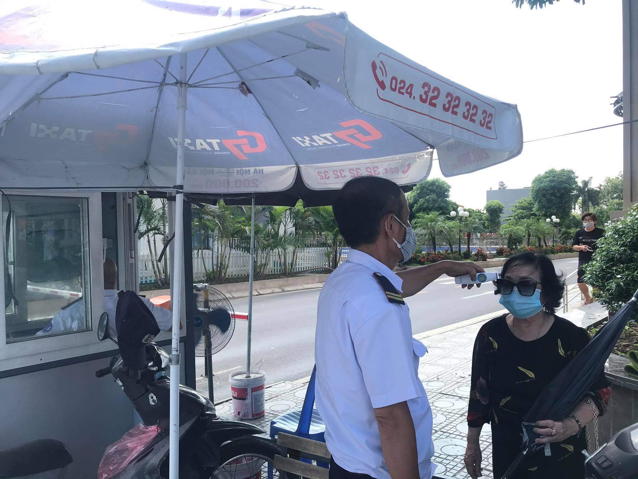 Bảo vệ tòa nhà Ruby City thực hiện đo thân nhiệt cho cư dân