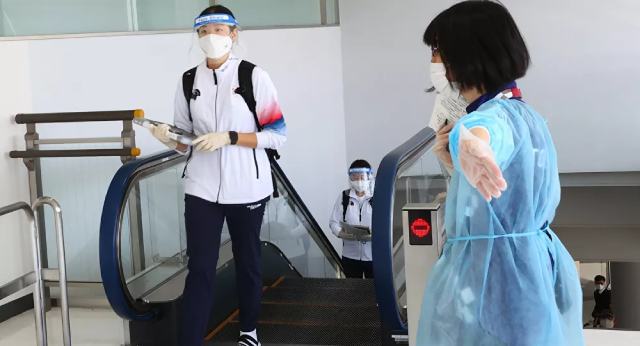 Thành viên đội tuyển quốc gia Hàn Quốc đeo khẩu trang ở sân bay Narita.