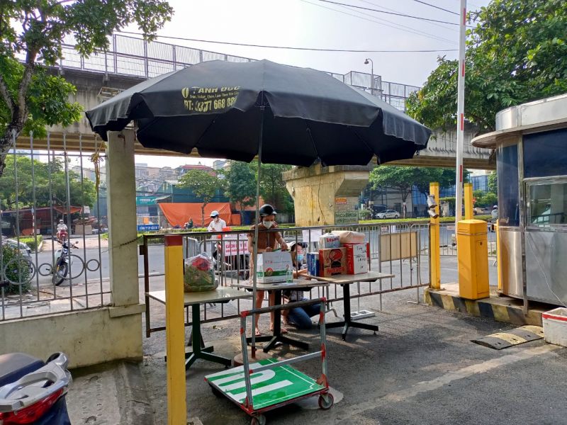 Bàn nhận tiếp tế nhu yếu phẩm, thực phẩm đến cho người thân đang cách ly tại các toà nhà trong khu chung cư đặt ngay ở hai cổng ra - vào
