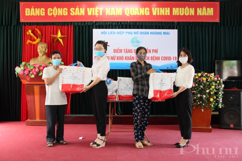 Chị Nguyễn Lệ Hằng - Chủ tịch Hội LHPN quận Hoàng Mai (ngoài cùng bên phải) và chị Nguyễn Mai Anh - Phó Chủ tịch Hội LHPN quận Hoàng Mai (thứ 2 từ trái) tặng quà cho gia đình hội viên phụ nữ khó khăn phường Vĩnh Tuy.